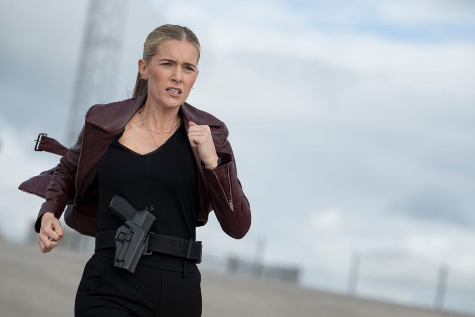 A person running with a firearm holstered at their side