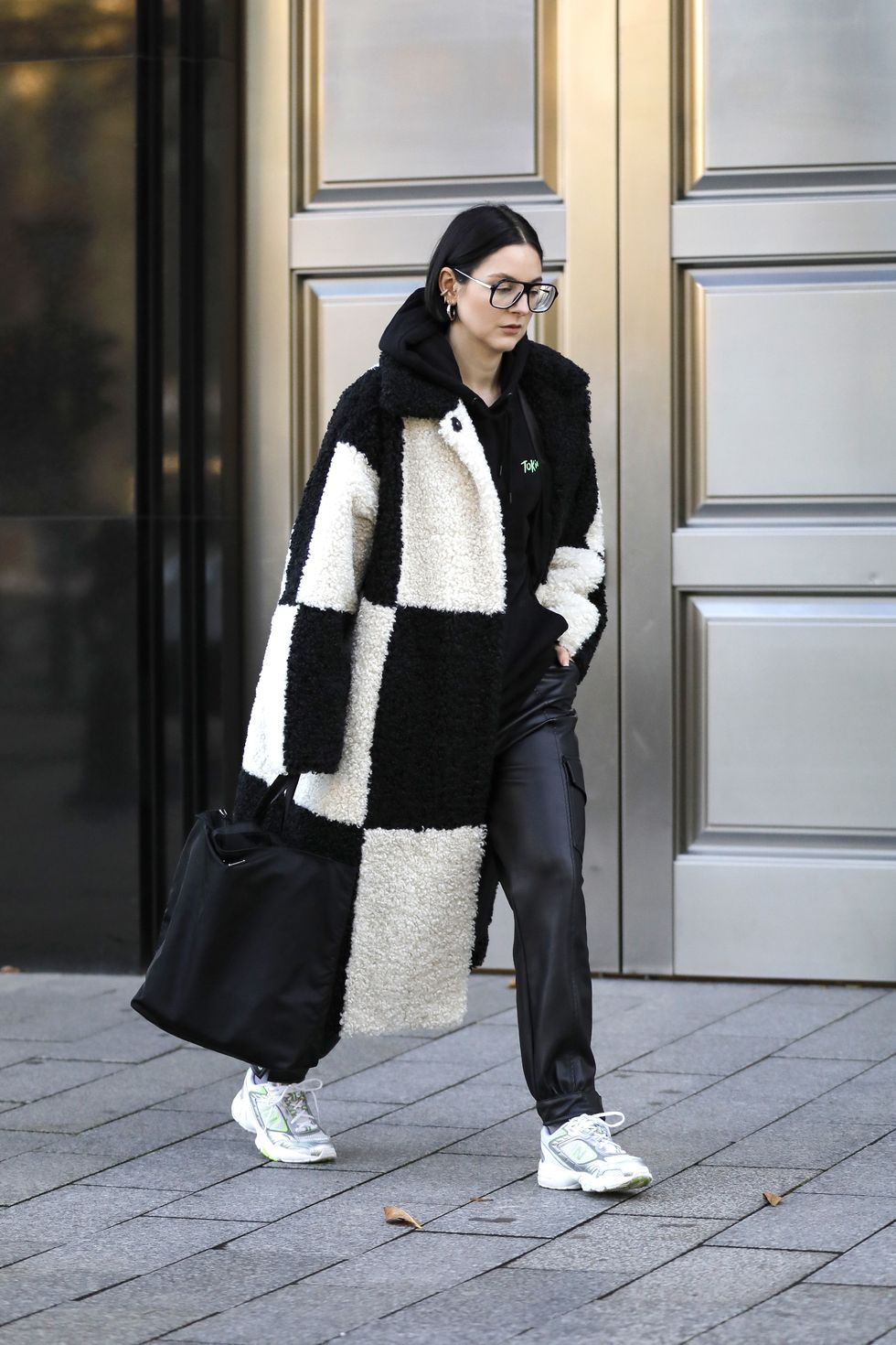 duesseldorf, germany   november 15 influencer maria barteczko, wearing a black and white checkered faux fur oversized coat by stand studio, a black hoodie by tokio hotel, black faux leather cargo pants by zara, white sneaker by new balance, a black nylon shopper bag by prada and black frame oversized aviator glasses by victoria beckham during a street style shooting on november 15, 2020 in duesseldorf, germany photo by streetstyleshootersgetty images