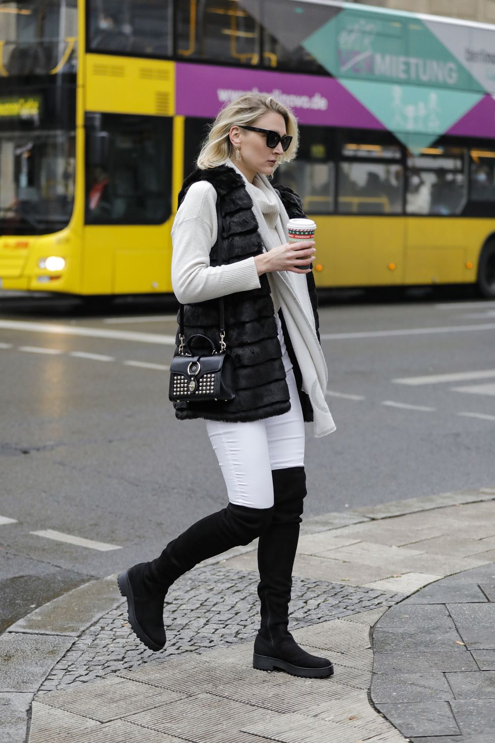 berlin, germany   december 11 german model and actress victoria jancke wearing a black faux fur vest by karl lagerfeld, a beige cashmere scarf by gucci, a cream colored turtleneck pullover by vero moda, a black bag with gold studs by aigner, white pants by top shop, black wide fit platform overknee boots by evenodd, gold earrings by lea y paola and black sunglasses by pilgrim during a street style shooting on december 11, 2020 in berlin, germany photo by streetstyleshootersgetty images