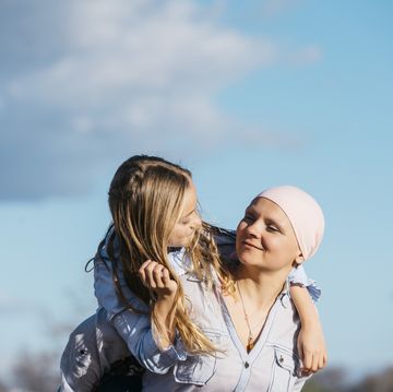 een vrouw met borstkanker knuffelt met haar dochter