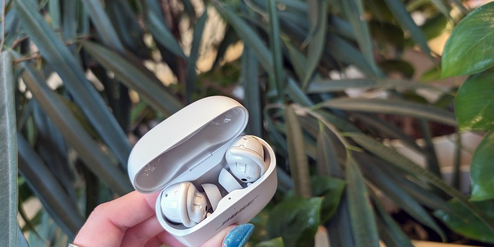 true wireless earbuds in charging case held up in a hand