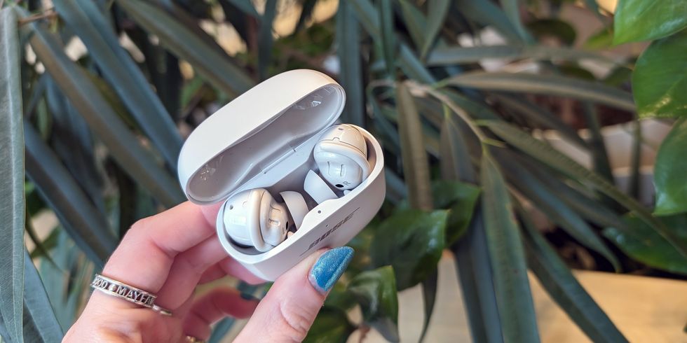 true wireless earbuds in charging case held up in a hand