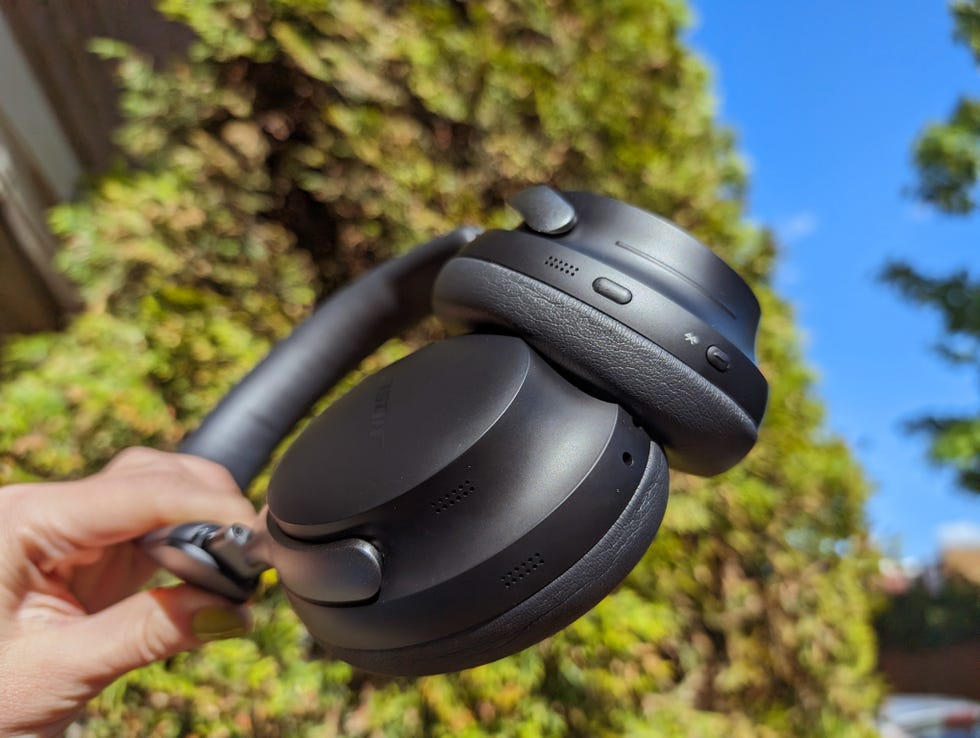 bose quietcomfort ultra headphones held up against blue sky