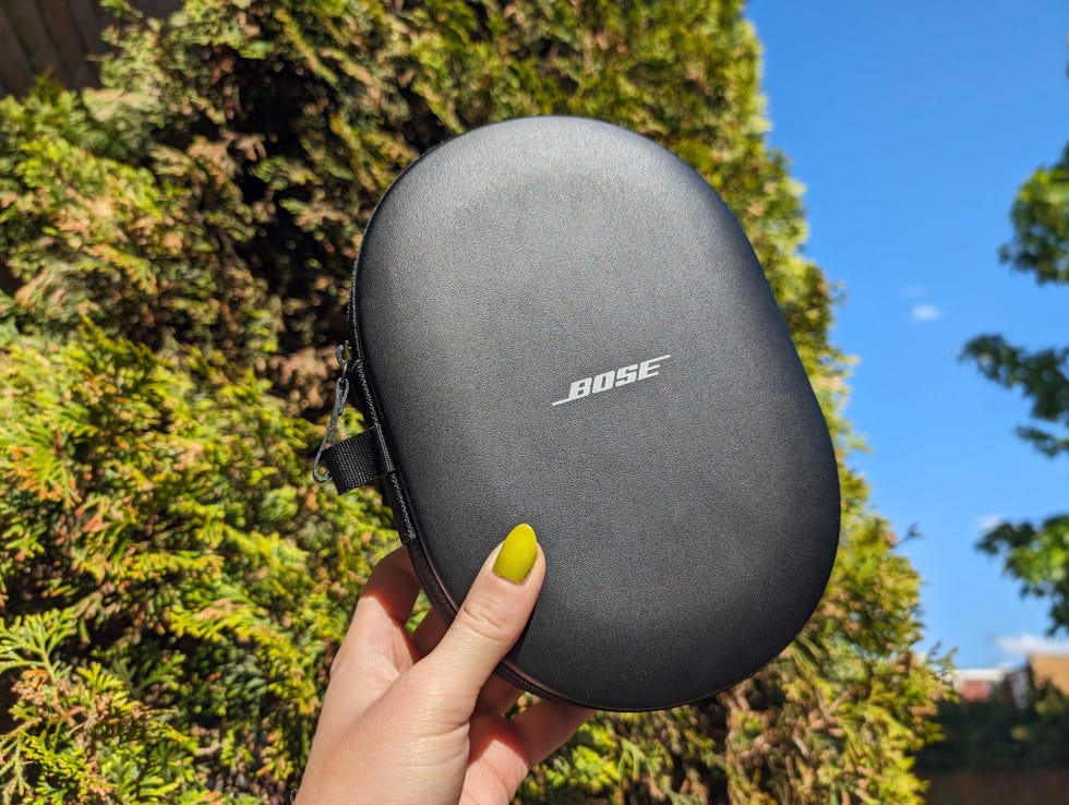 bose quietcomfort ultra headphones held up against blue sky