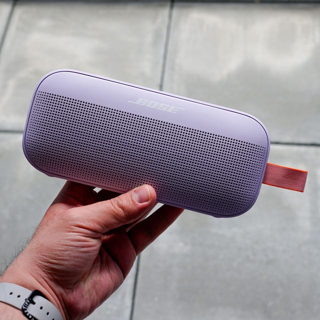 a hand holding a bose soundlink flex portable bluetooth speaker