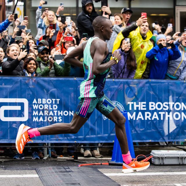 evans chebet running the boston marathon with a crowd watching
