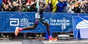 evans chebet running amortiguaci the boston marathon with a crowd watching
