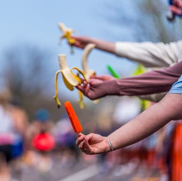 RWD people hold out a popsicle and bananas for runners in a race