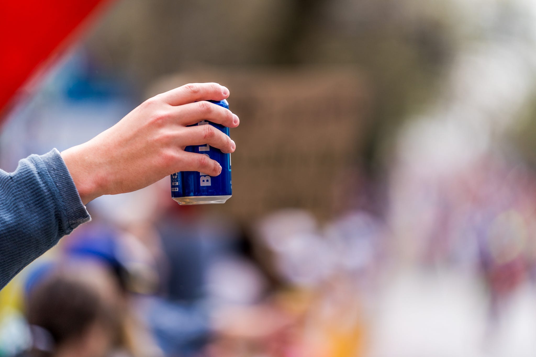 a person holding a can of beer
