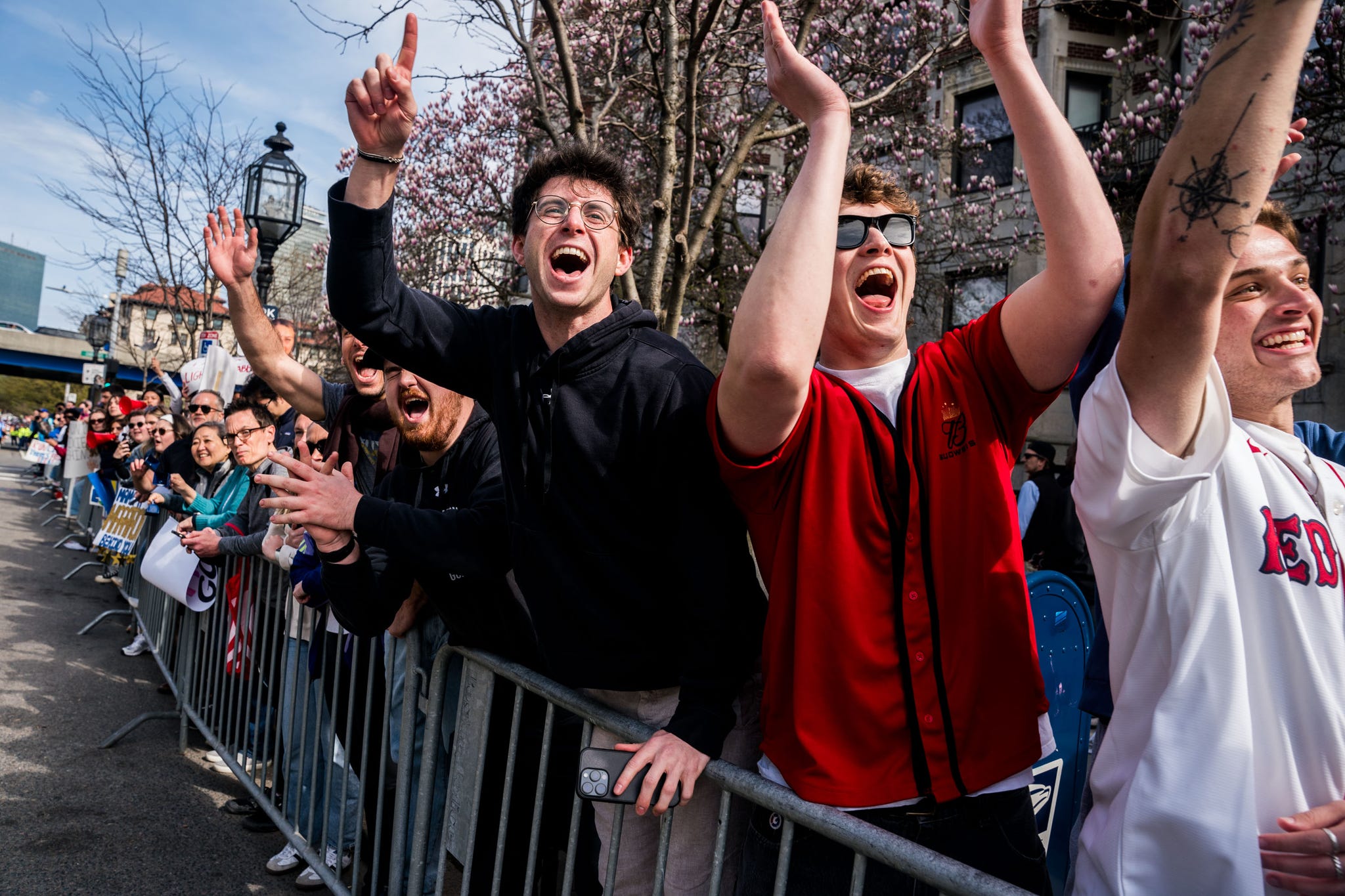 a group of spectators lining a running race course cheer