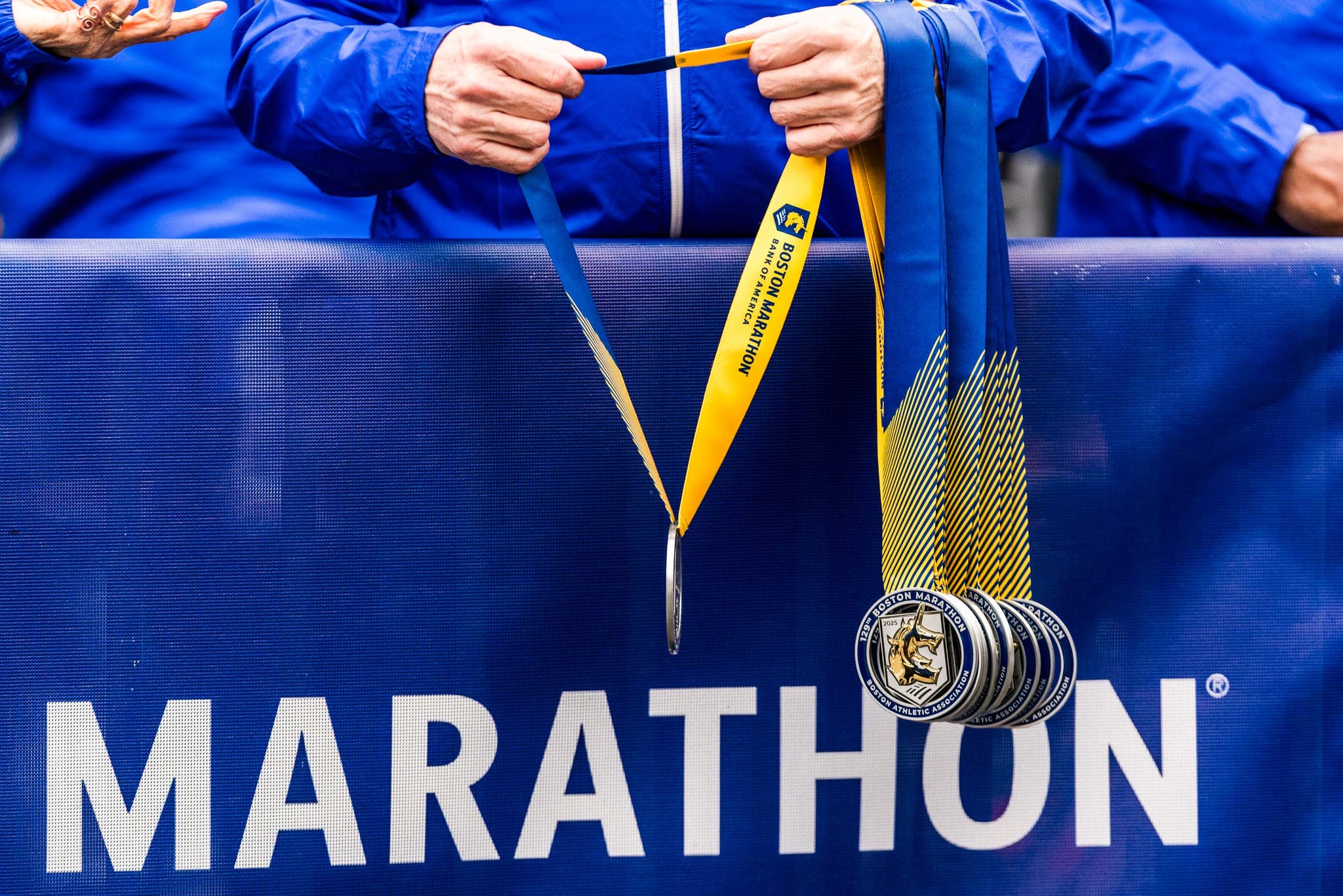 people holding medals for the boston marathon