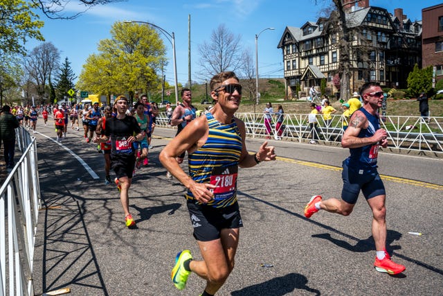 Runners participating in a marathon event alongside a road lined with spectators