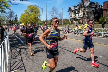 Runners participating in a marathon event alongside a road lined with spectators