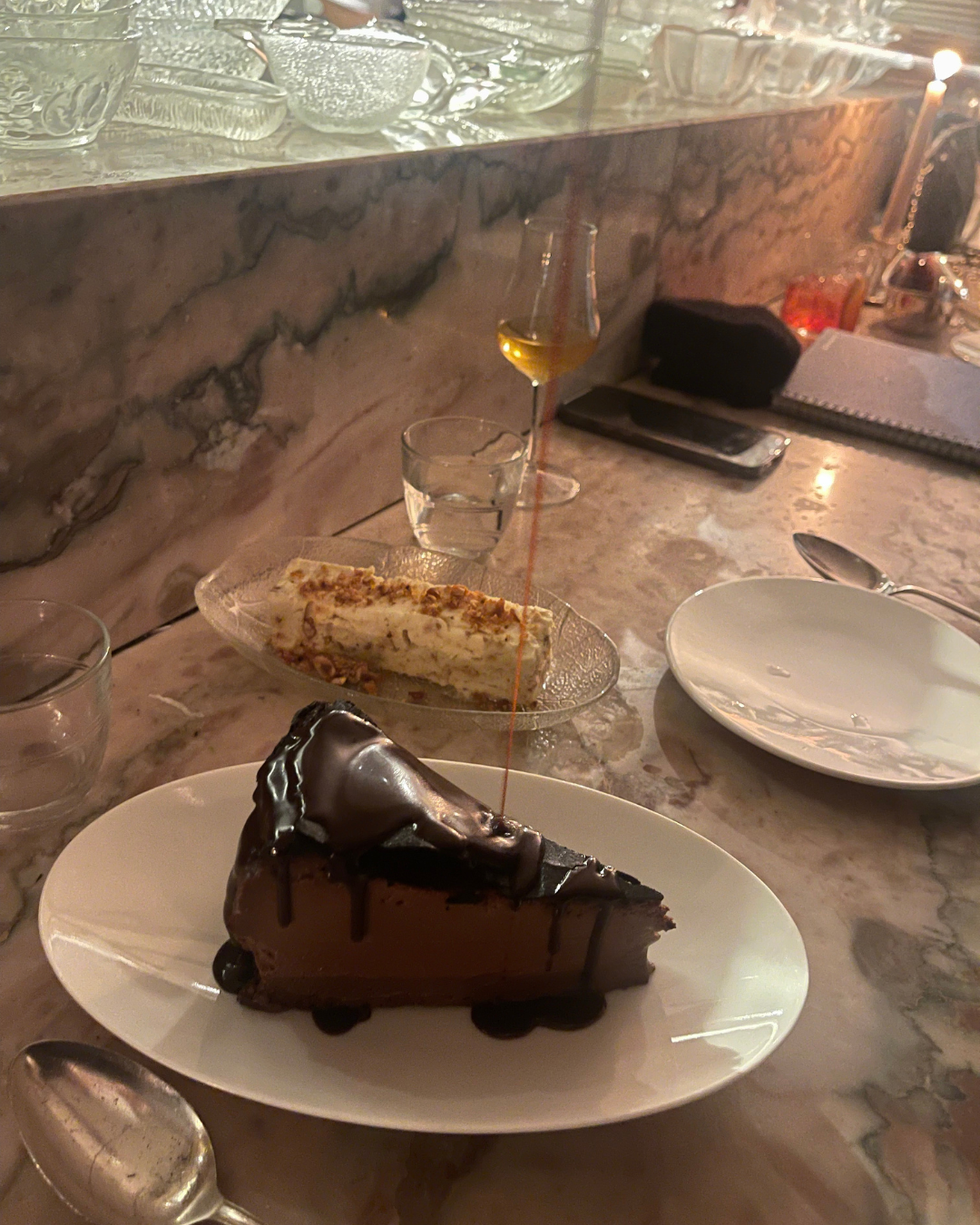 dessert selection featuring a slice of chocolate cake and a portion of dessert topped with nuts