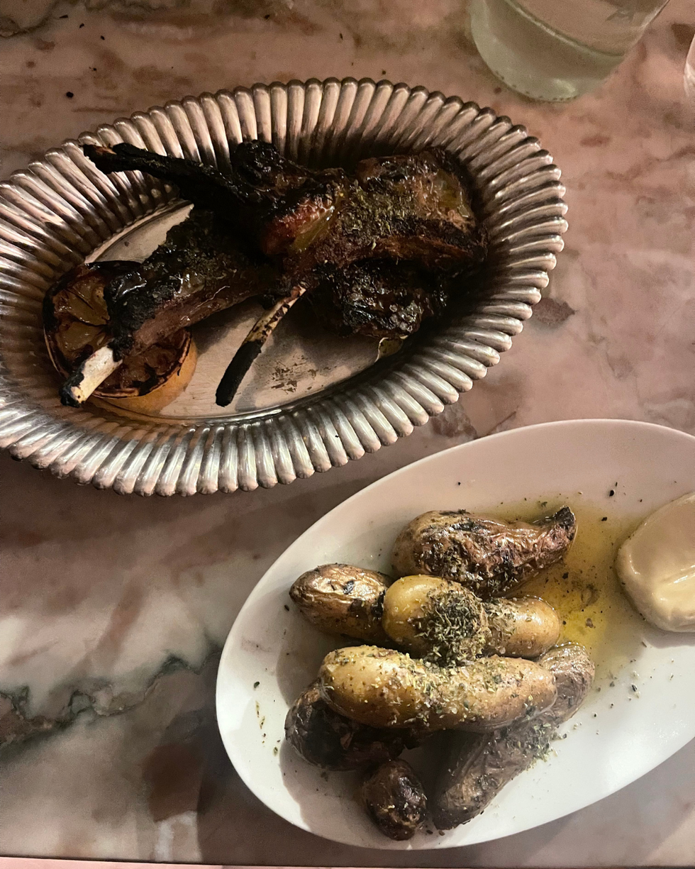 grilled lamb chops and seasoned potatoes served on plates