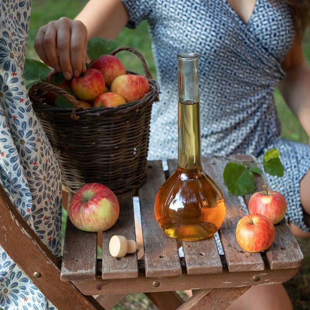 a bottle of apple cider vinegar with fresh apples