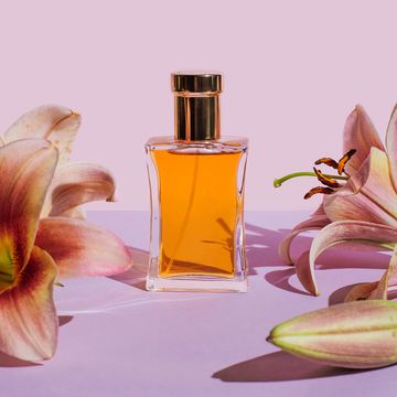 bottle of perfume with lily flowers on purple background beauty products for body and face care minimal style perfumery template