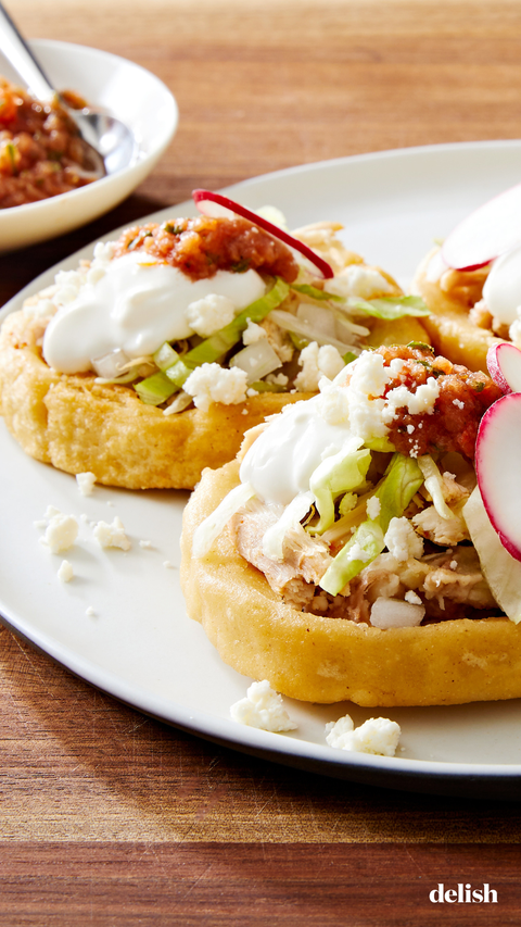 sopes made of masa harina and topped with refried beans salsa roja shredded lettuce mexican crema radishes and cojita