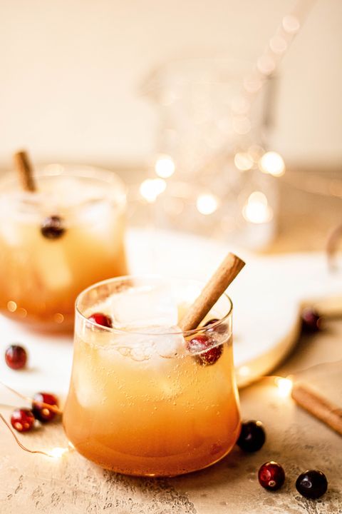 bourbon apple cider fizz with cranberries and cinnamon stick