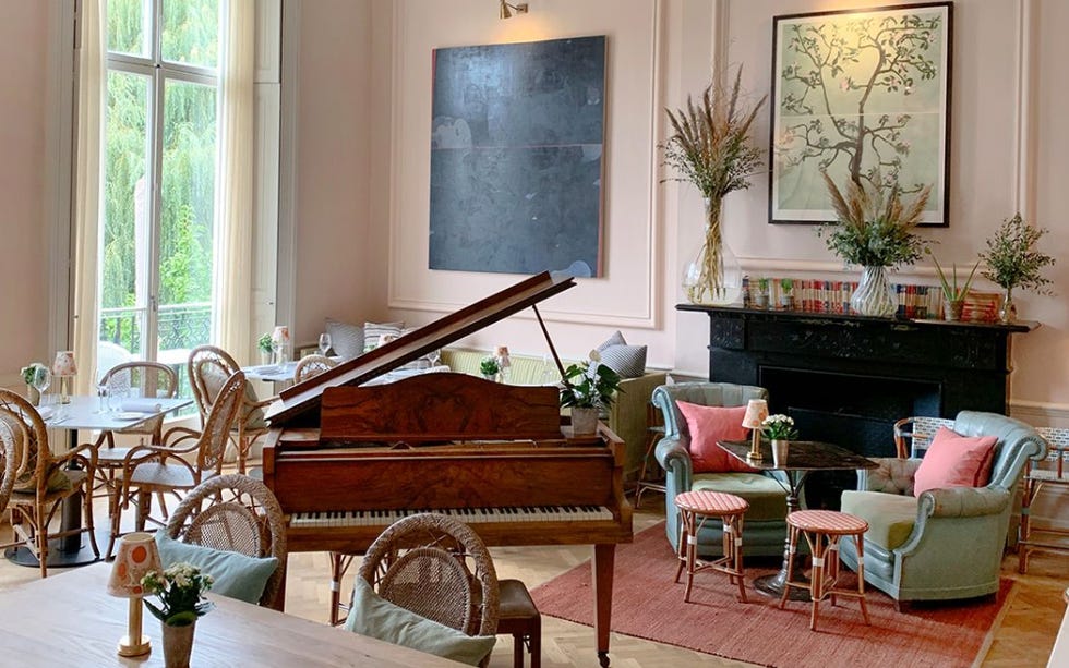 lounge area with piano surrounded by tables and chairs