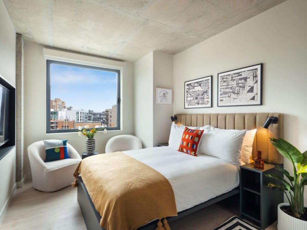 a bedroom with a large window and bed