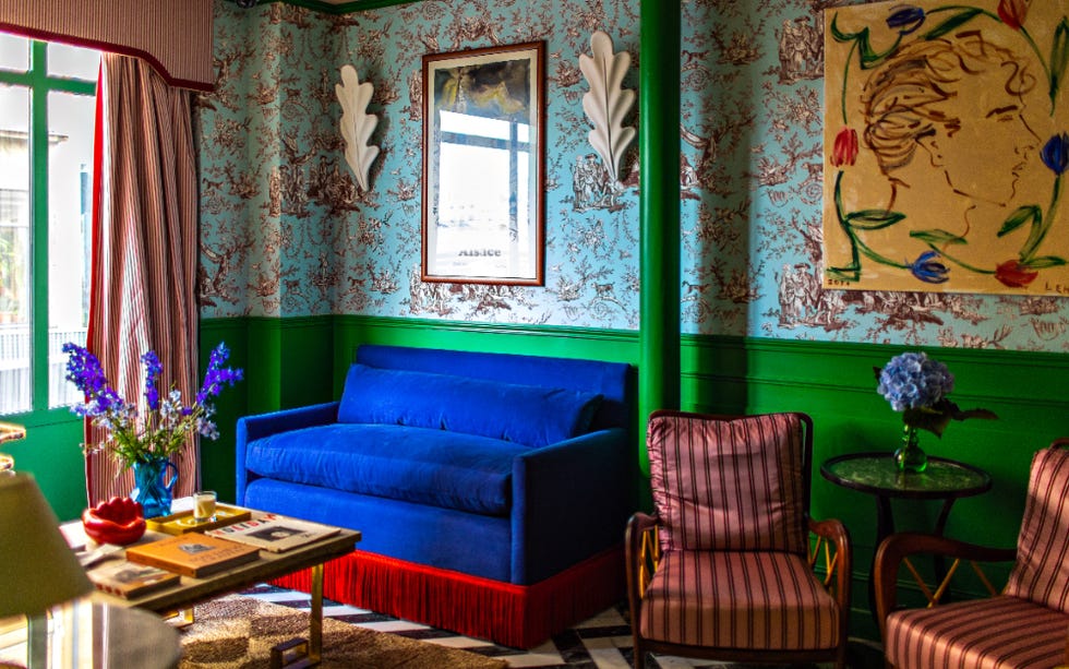 a living room with a blue couch and patterned wallpaper at hotel les deux gares
