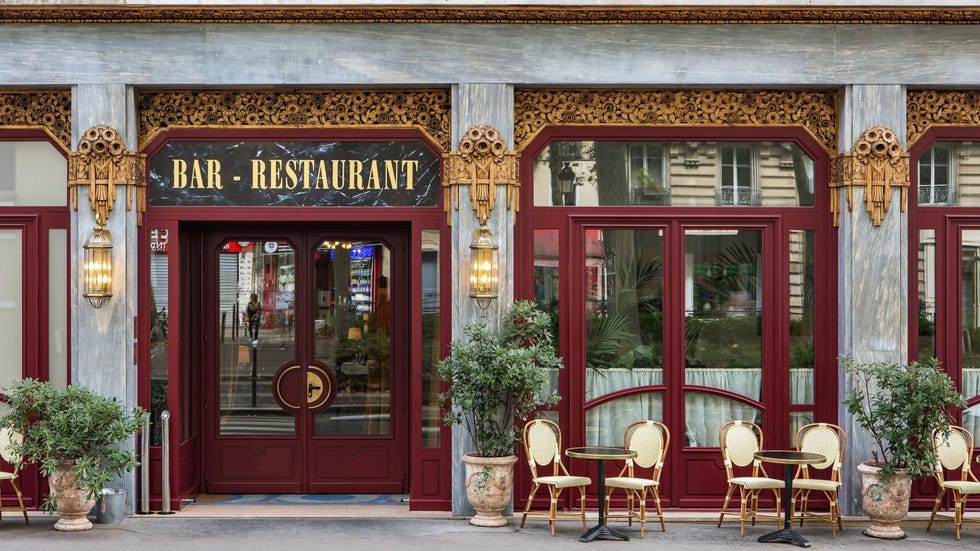exterior of hotel rochechouart with red doors and cafe seating outside