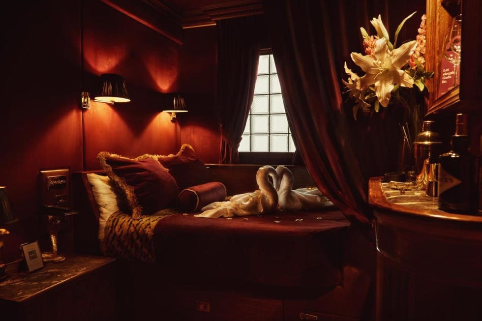 two towel swans laying on a bed