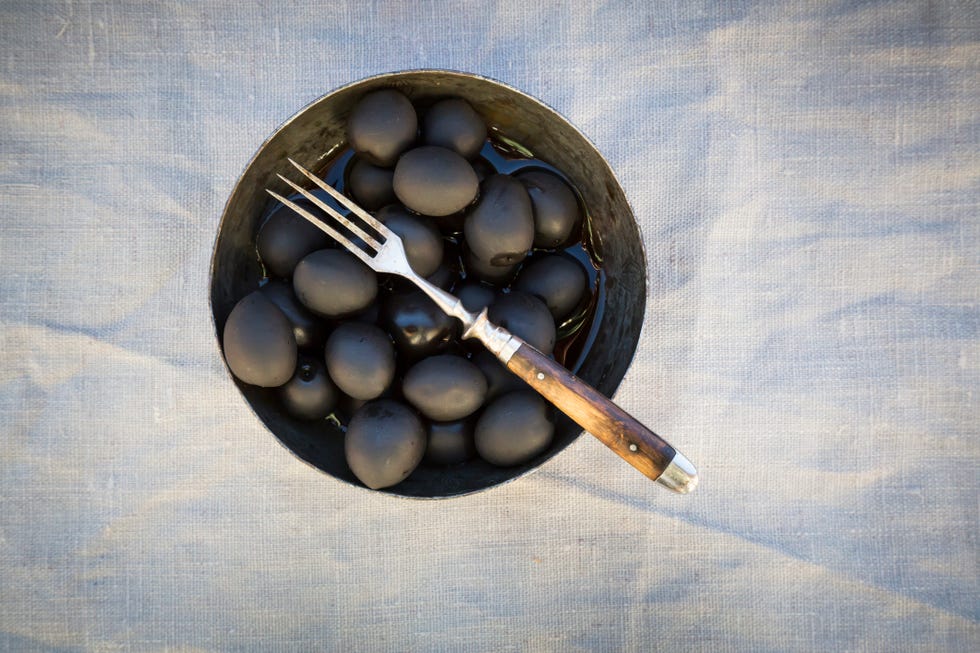 un bol con aceitunas negras y un tenedor