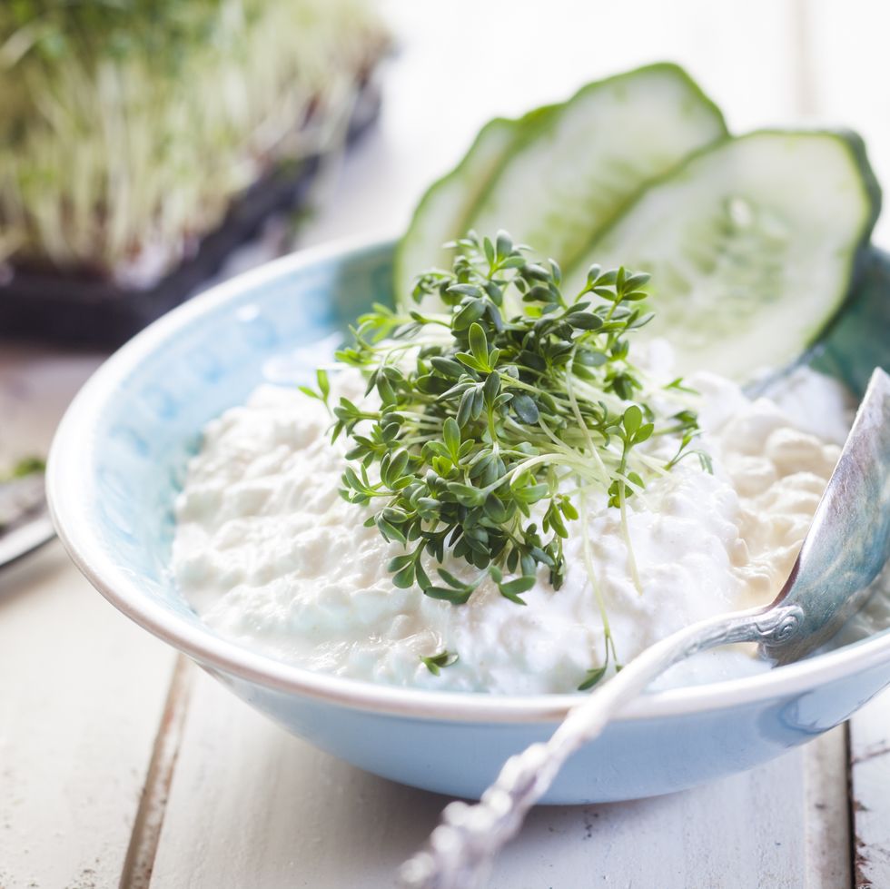 Bowl of cottage cheese with cress and cucumber slices
