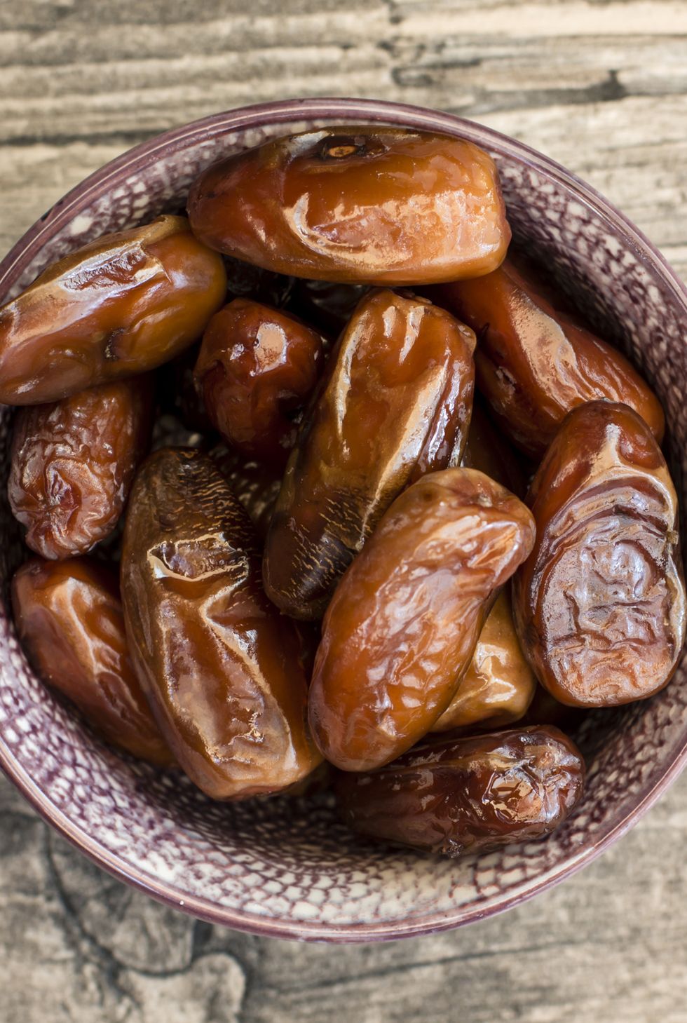 Bowl of dates on wood