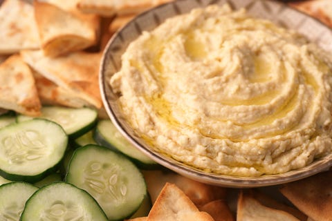 a bowl of fresh hummus and cucumbers