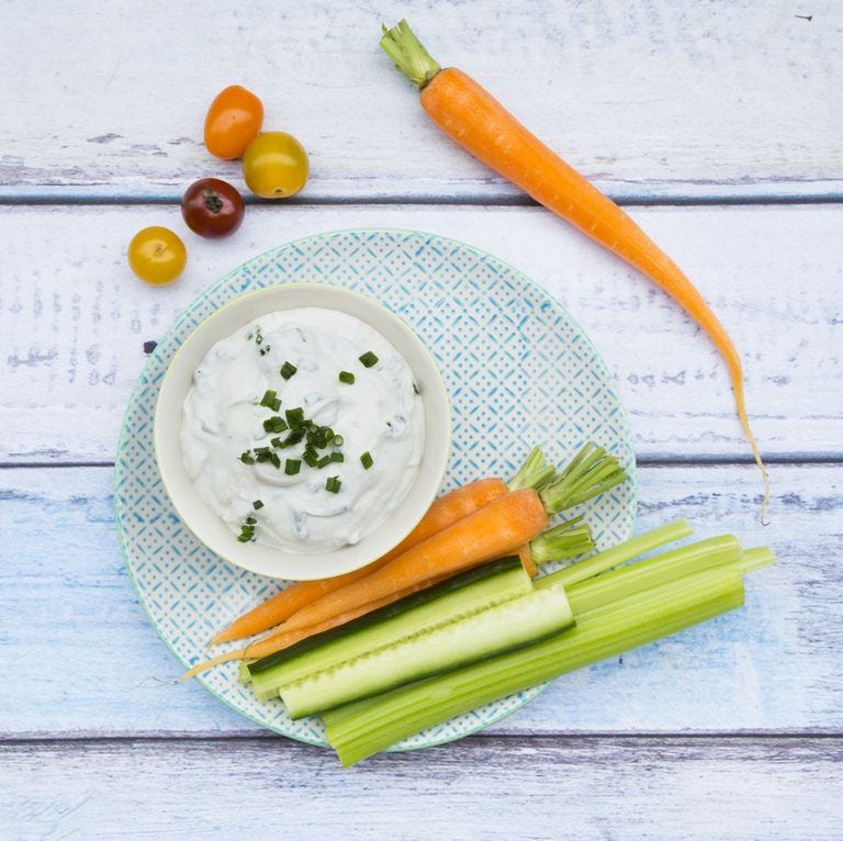 bowl of herb yoghurt dip and vegetable sticks on plate