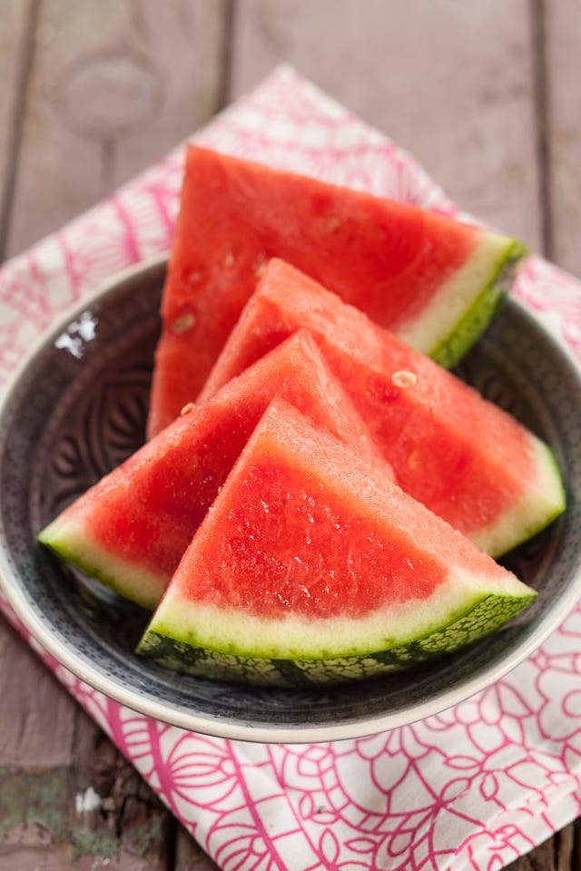 Bowl of melon slices on cloth and wood