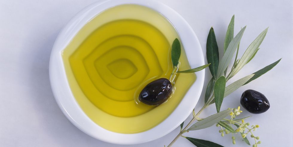 Bowl of olive oil, olives, twig of olive tree