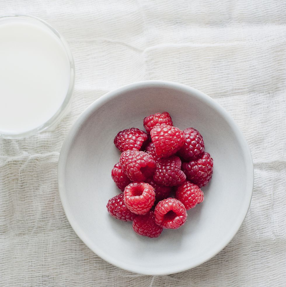 bowl of raspberries and a cup of milk