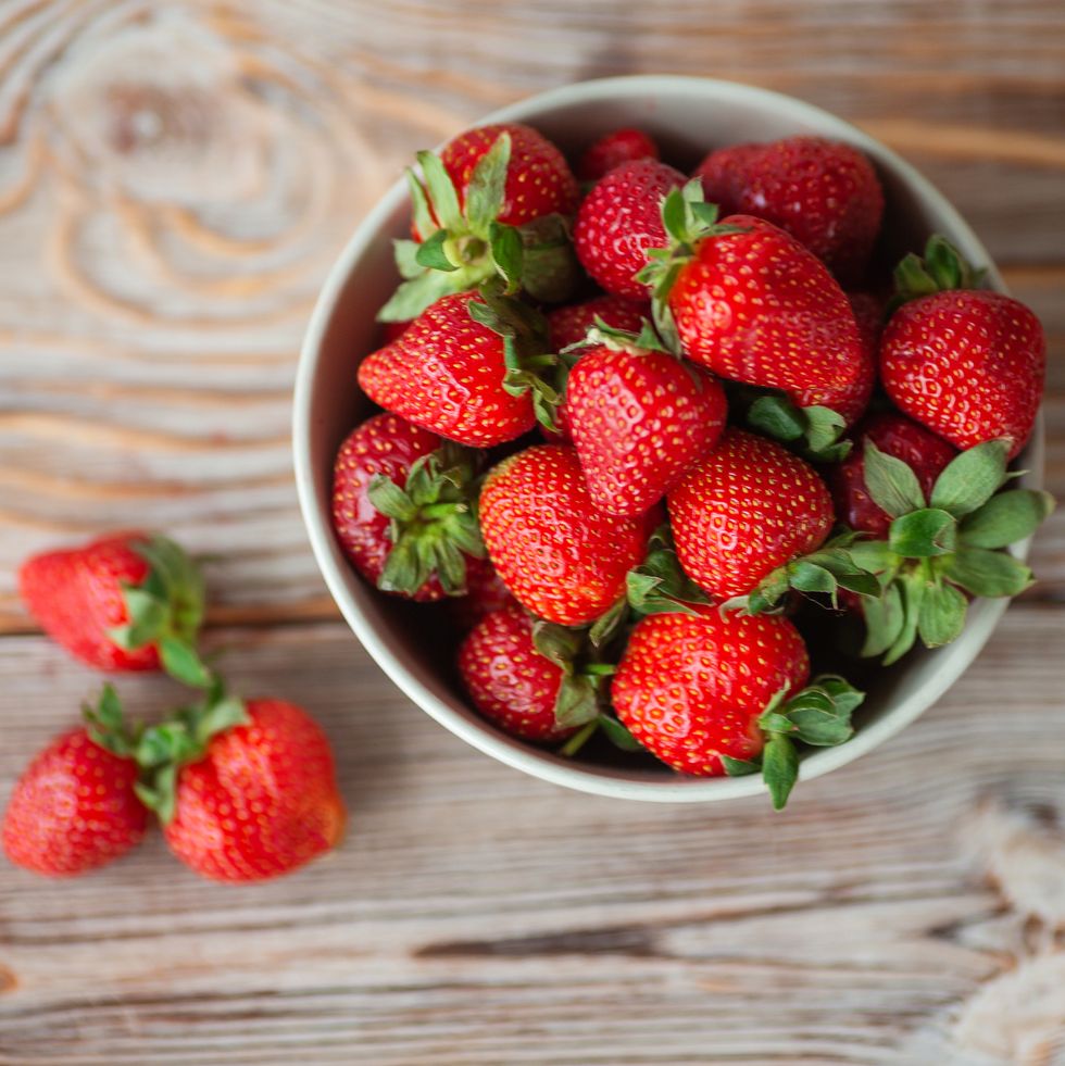 bowl of ripe strawberries on wooden  table  stock photo