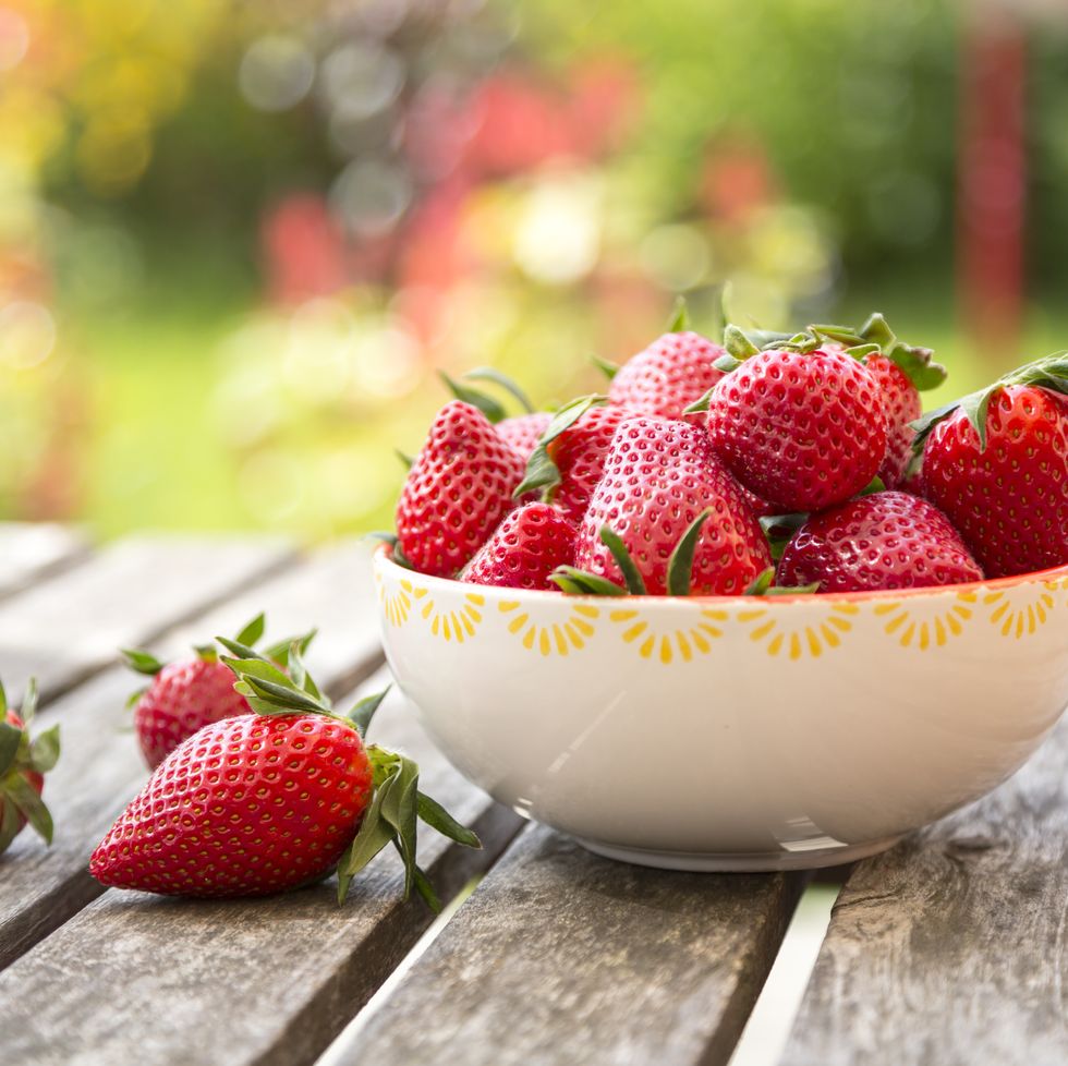 bowl of strawberries on wooden garden table