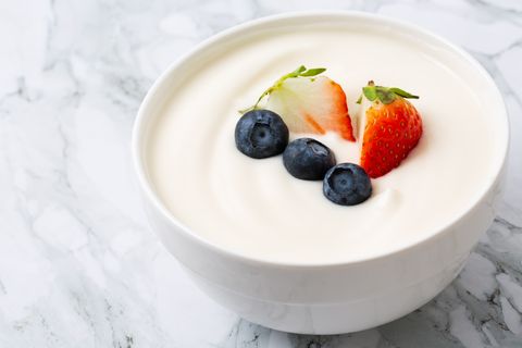 bowl of yogurt and fresh berries on white fresh yogurt, strawberries, blueberries, handmade