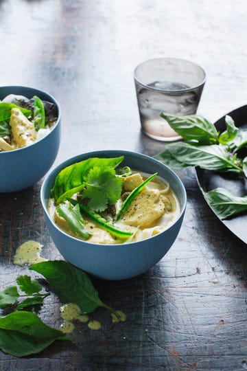 bowls of chicken laksa and herbs