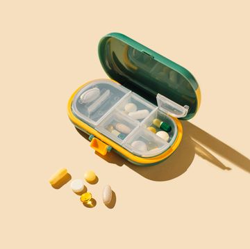 box for pills and capsules on beige background. pills organizer. minimal medical, health care, pharmacology concept.