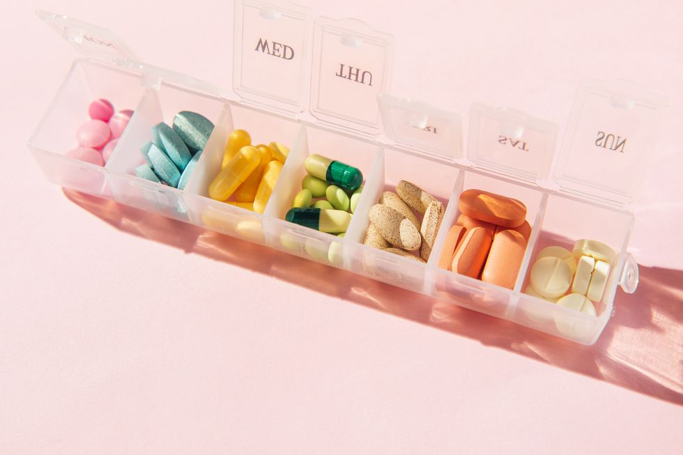 box for pills and capsules on pink background pills organizer