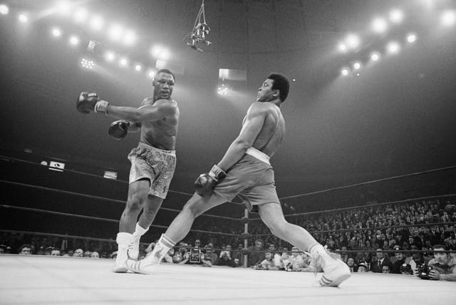 Boxer Muhammad Ali steps away from a punch thrown by boxer Joe Frazier during their heavyweight title fight at Madison Square Garden in 1971