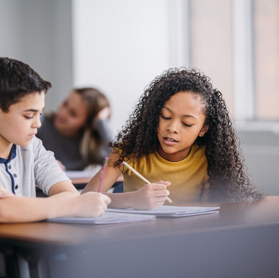 boy and girl work together in class to solve schoolwork