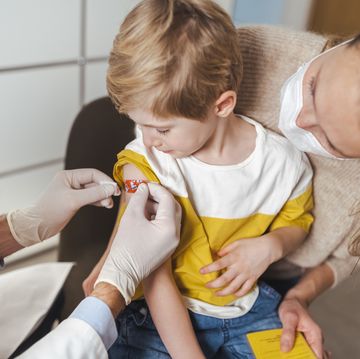 boy getting bandage by doctor after vaccination at center