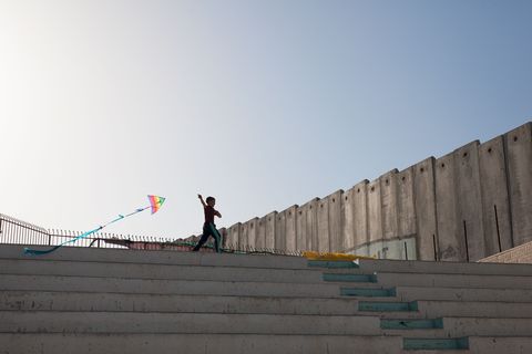 een palestijns jongetje is aan het vliegeren in het vluchtelingenkamp aida waar meer dan 5500 palestijnse vluchtelingen wonen