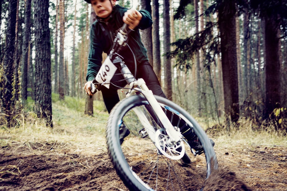 un chico practica bicicleta de montaña en medio del campo