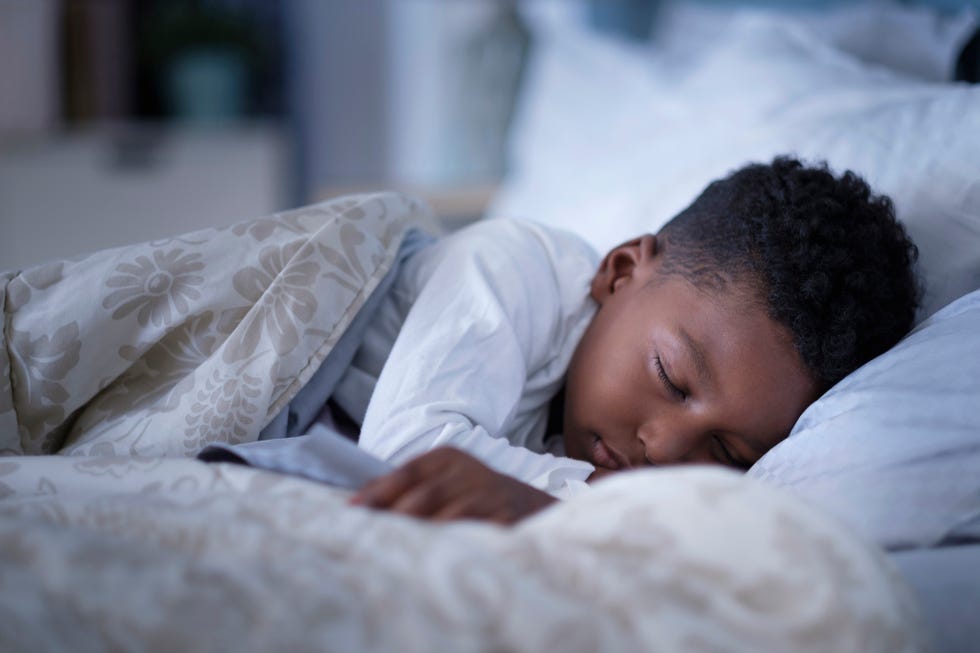 a child sleeping on a bed