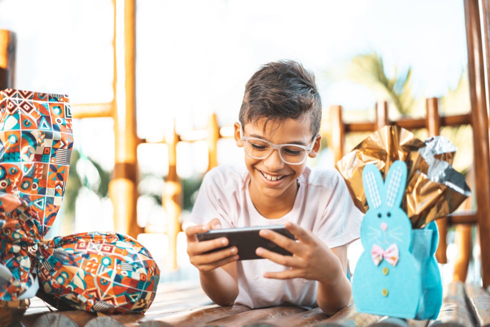 boy using smartphone and celebrating easter