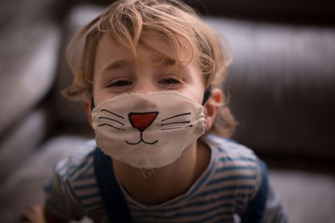 boy wearing a surgical mask painted as a cat